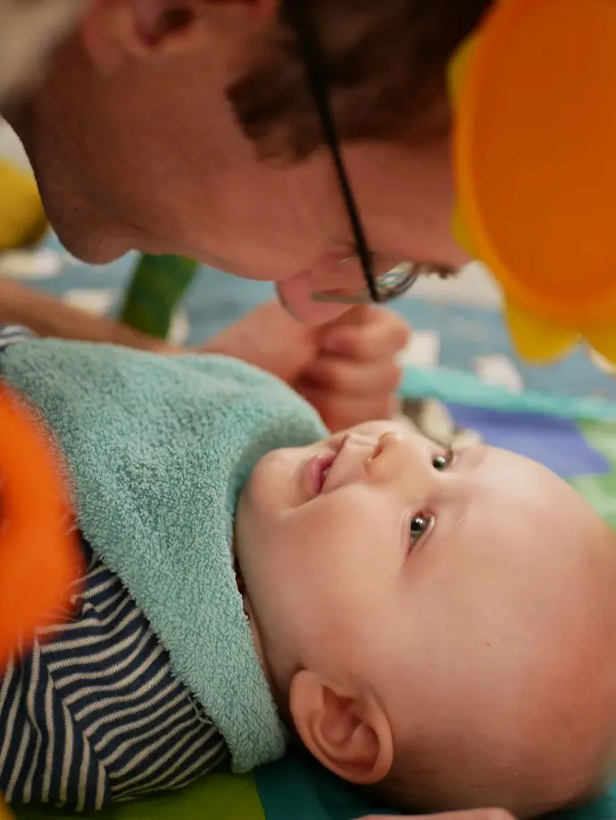 face à face d'un bébé souriant et son père