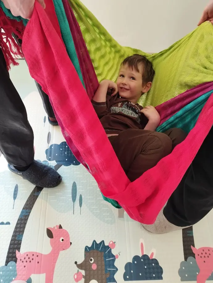 un enfant instalé comme dans un hamac , dans des rebozo soutenu par des adultes